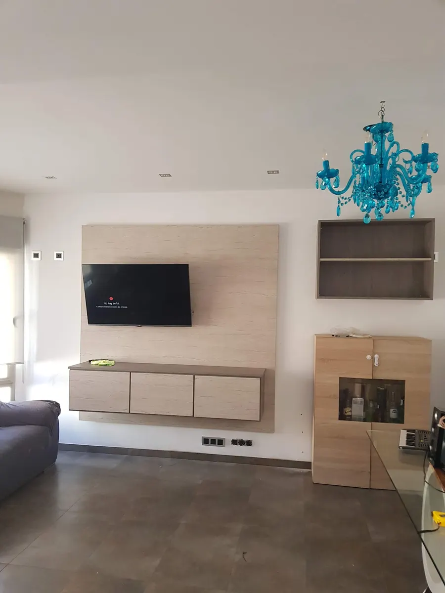 Mueble de salón y TV a medida con panel mural y estante de madera en Alicante