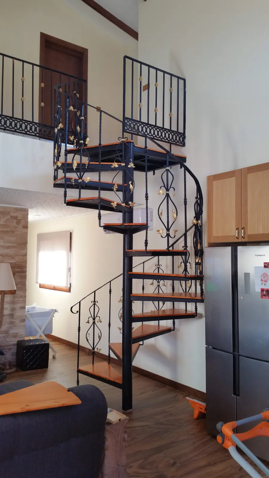 Escalera de caracol con peldaños de madera y forja fabricada a medida en Alicante